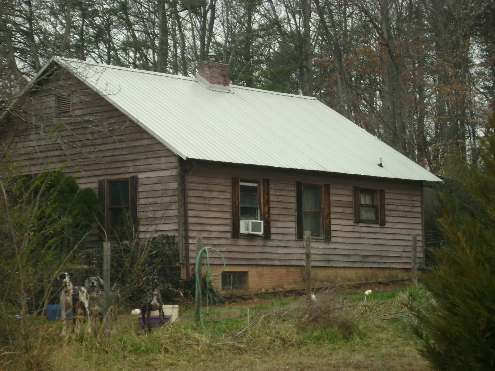 White metal roof on an old wood sided farmhouse, from a Metal Roof Installation job in Scottsville